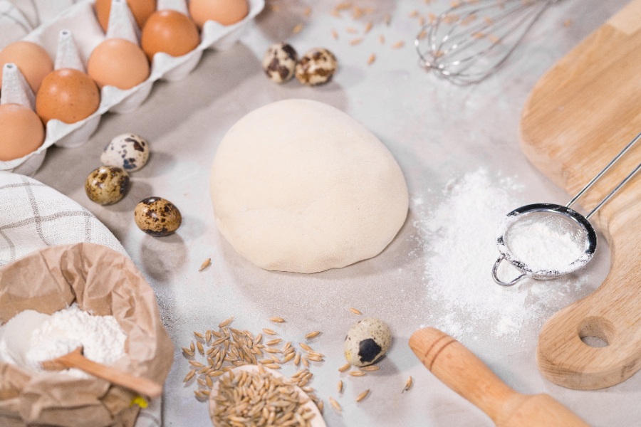 Un grand saladier contient une pâte à pain qui a levé toute la nuit