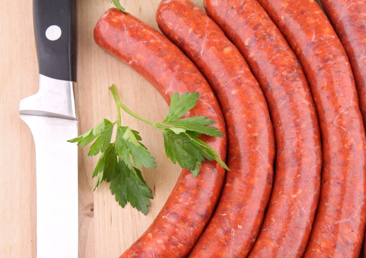 Des merguez déposés sur la table avec une feuille de persil