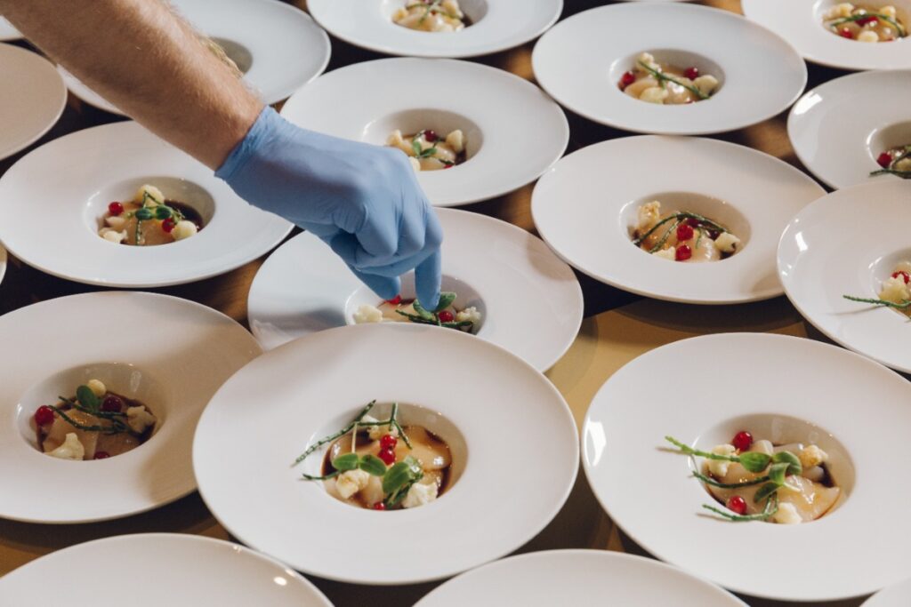 Un professionnel qui ajoute des ingrédients sur les plats