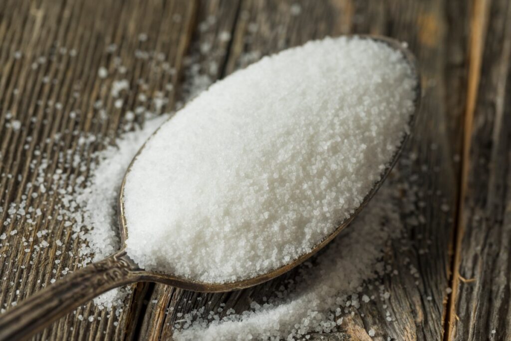 Une cuillère remplie de sucre blanc