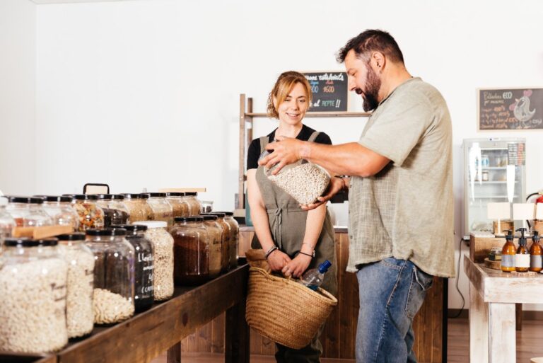 Un couple qui sélectionne des haricots dans des bacs dans une épicerie écologique