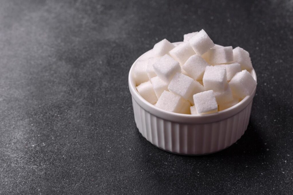 Un bol blanc rempli de morceau de sucre