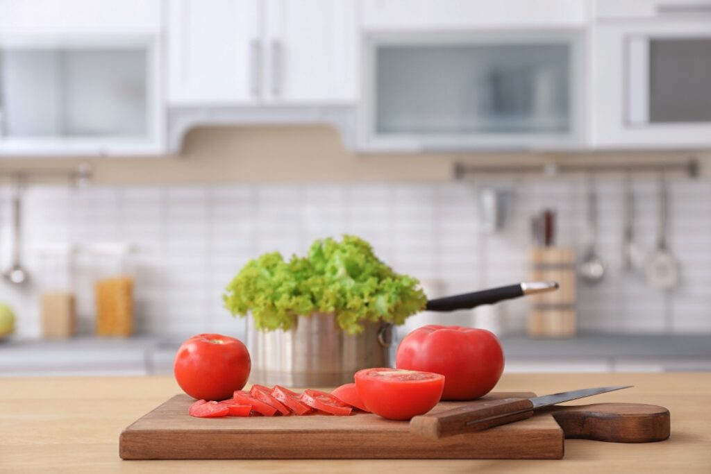 Un couteau, des tomates et des salades dans la cuisine