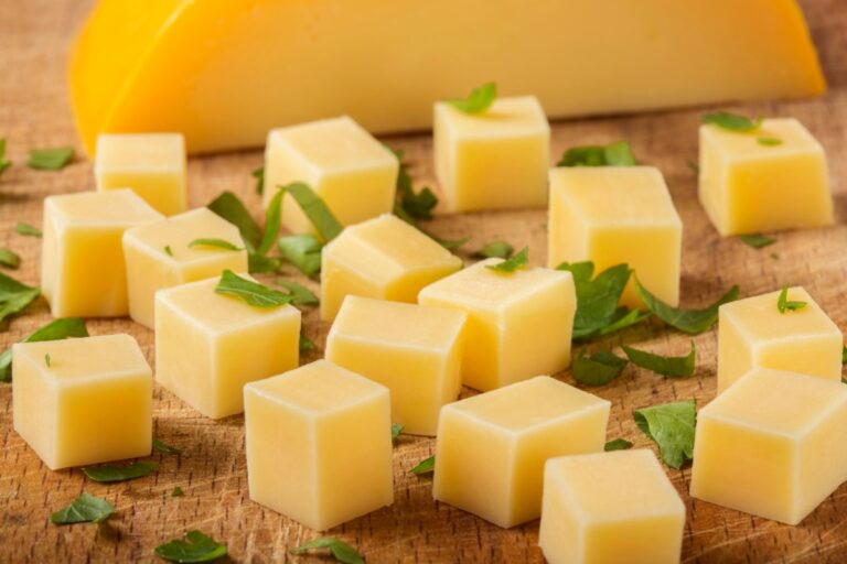 Des cubes de fromages et des feuilles vertes