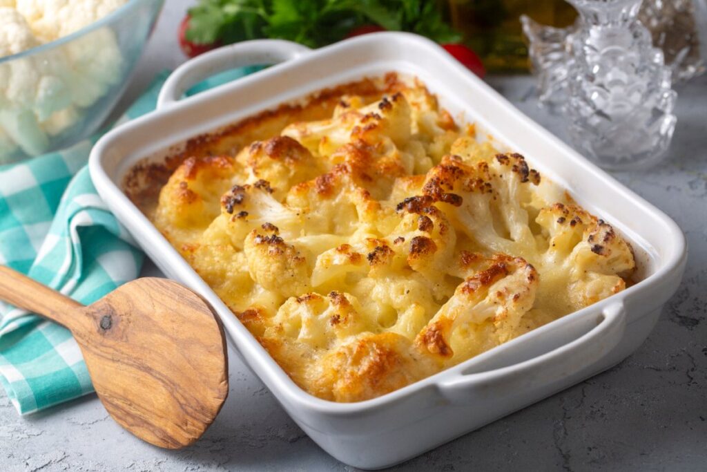 Gratin de chou fleur dans un plateau avec une louche en bois