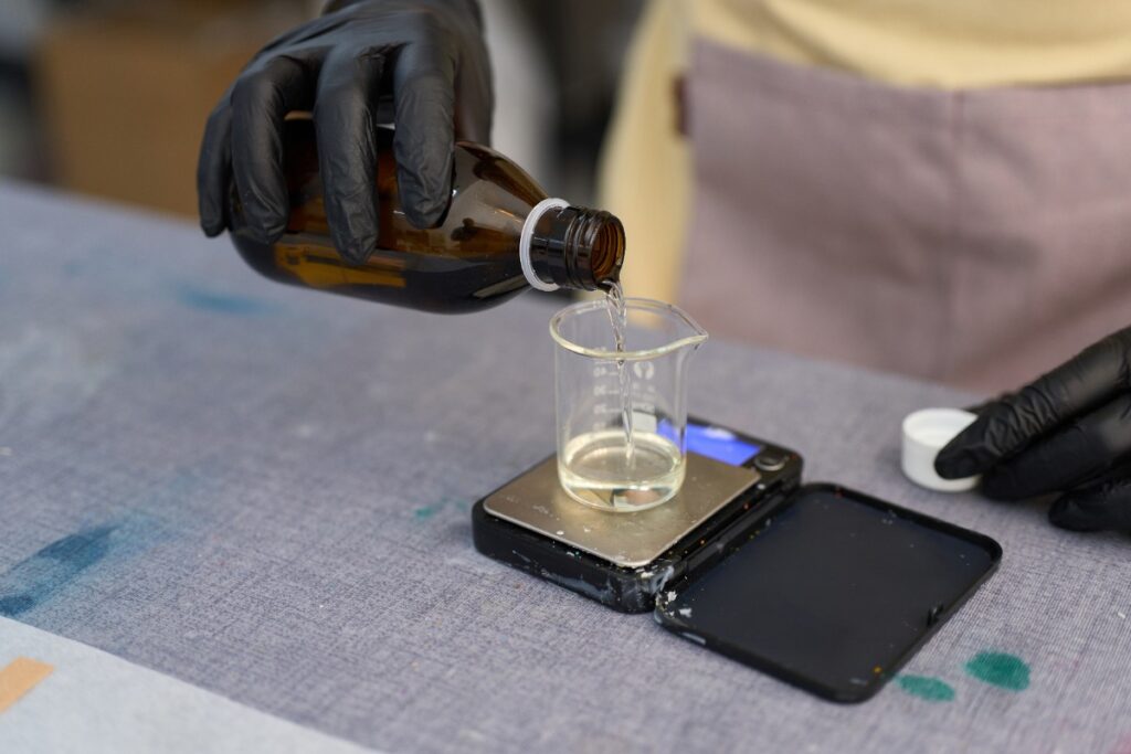 Une personne qui verse de l'huile dans un verre