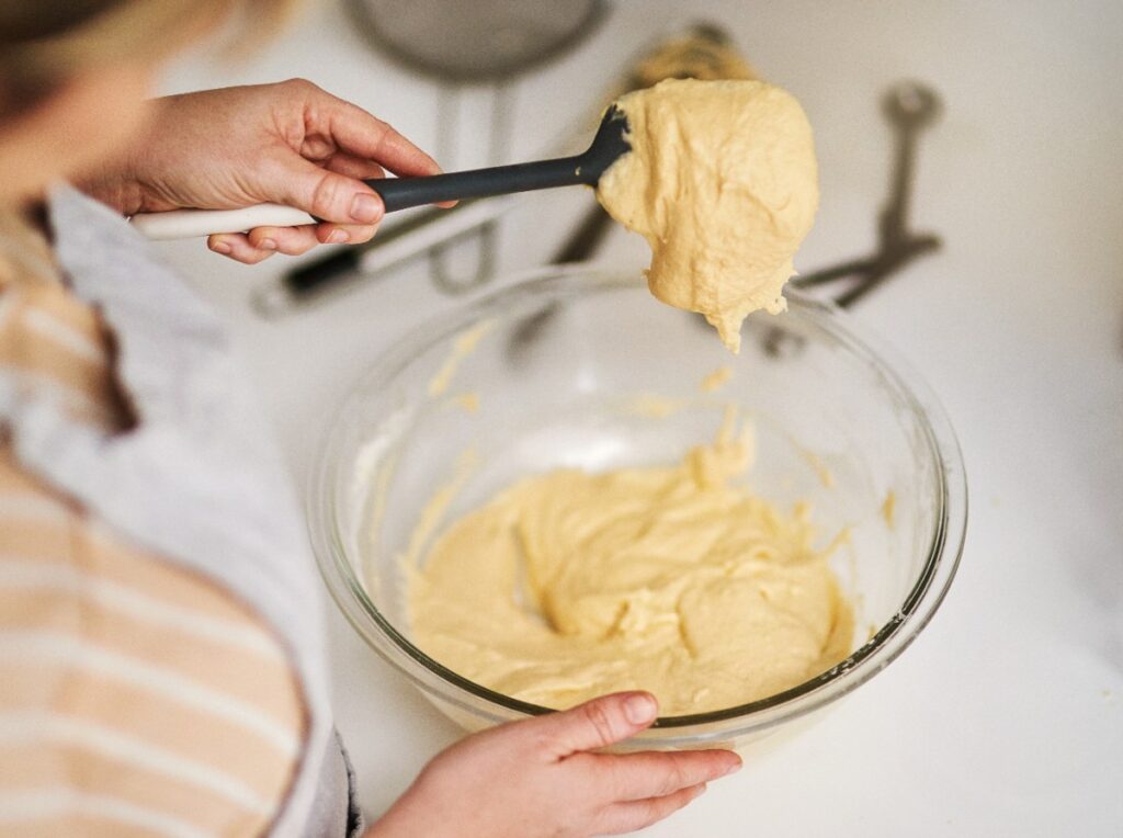 Une femme qui mélange des pâtes dans un bol