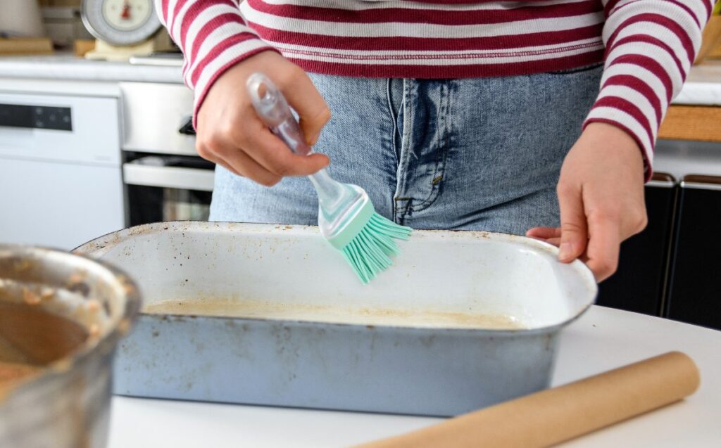 Une femme qui prépare un plat à four dans la cuisine