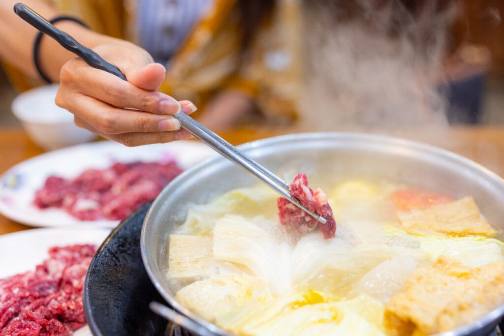 Une personne qui mange une fondue à viande