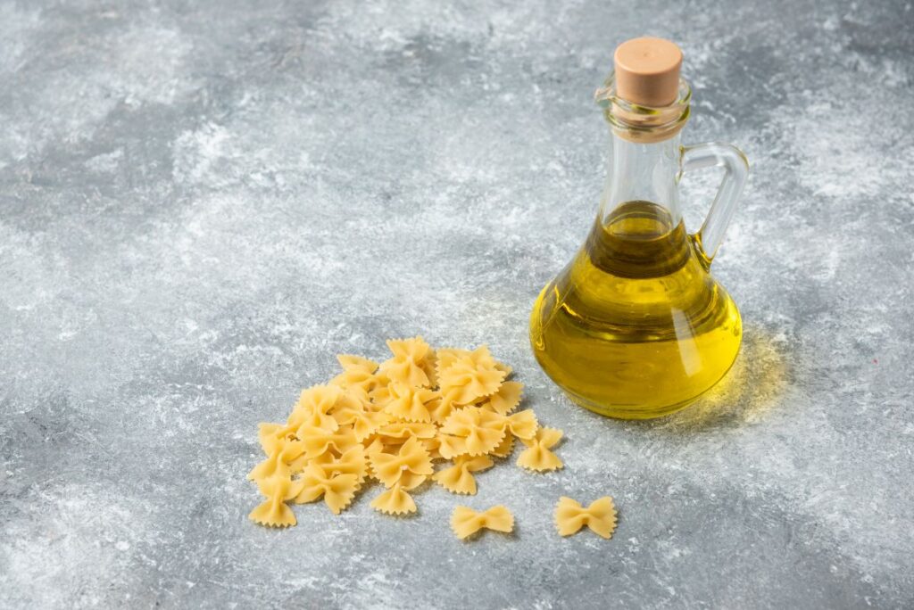 Une bouteille d'huile avec des pâtes sur la table