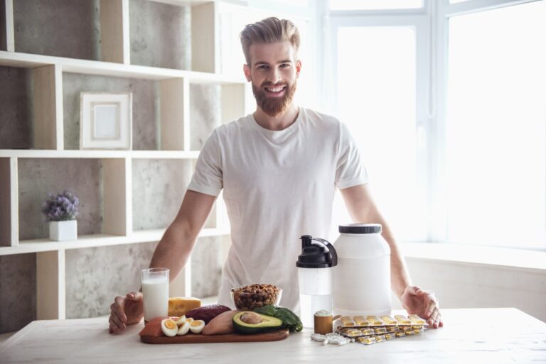Un homme souriant avec des nourriture saine sur la table