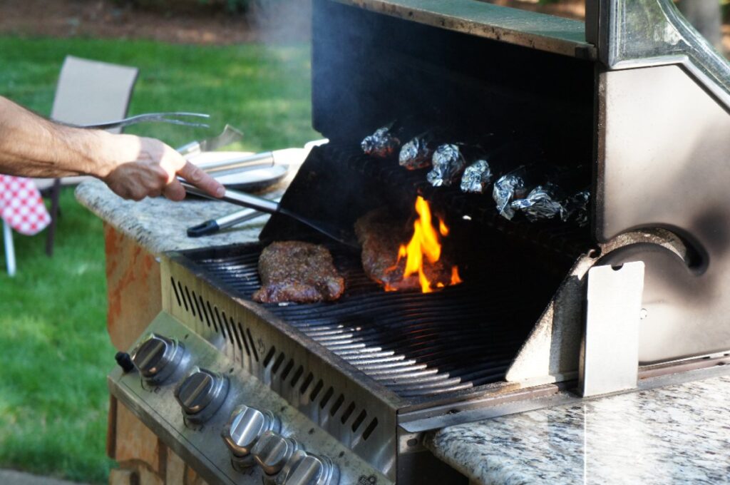 Une personne faisant de la barbecue à l'extérieur