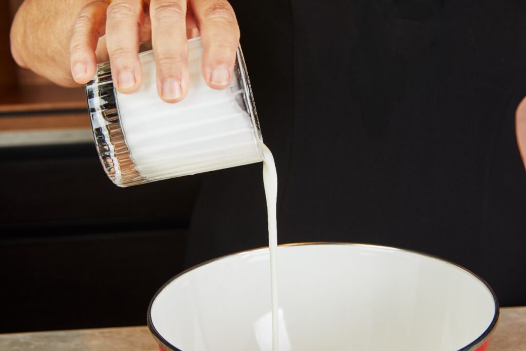 Une personne versant du lait dans un bol