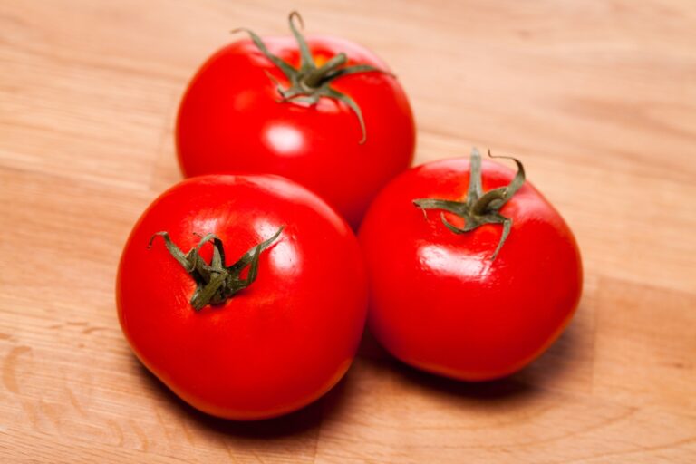 Des tomates rouges sur une surface en bois
