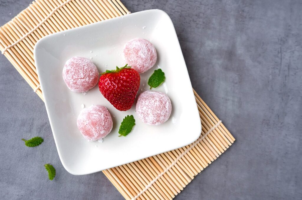 Une assiette avec des mochis et une fraise