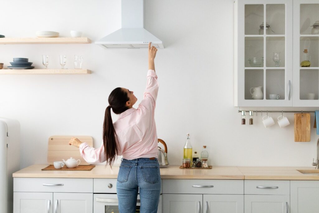 Une femme selectionnant le mode d'action d'une hotte