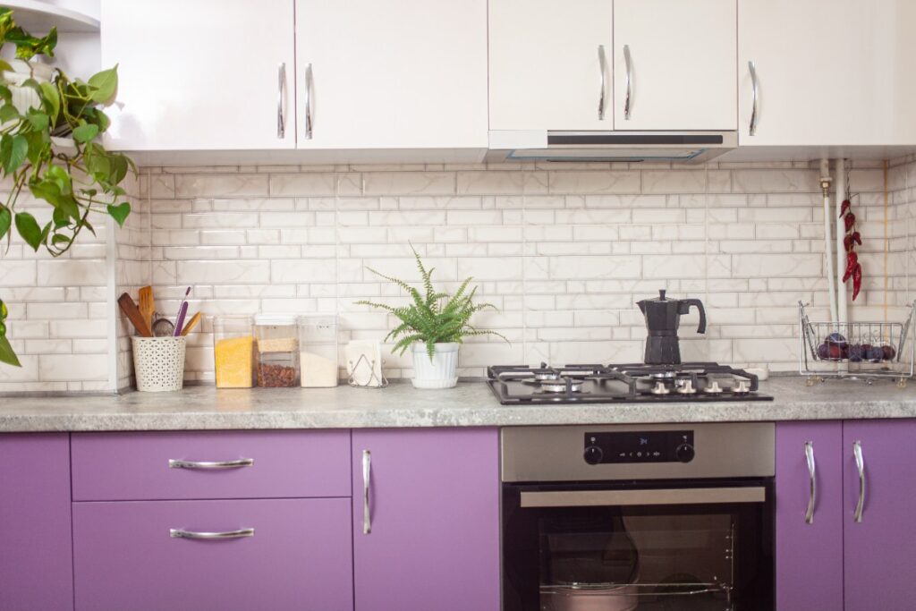 Intérieur de cuisine moderne avec des armoires violettes et de comptoirs blancs