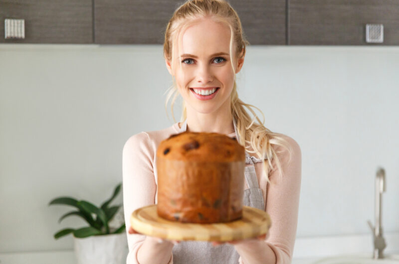 Une femme souriante ayant réussi la cuisson de son baba au rhum avec une recette de grand-mère