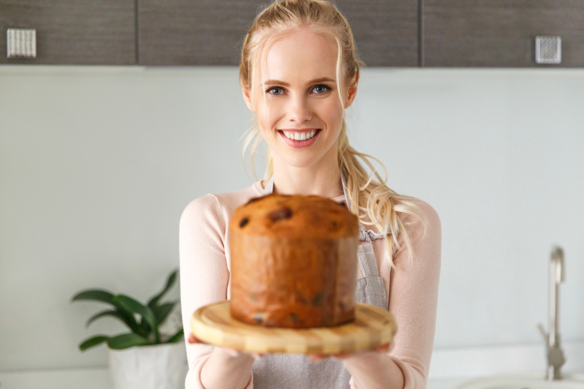 Une femme souriante ayant réussi la cuisson de son baba au rhum avec une recette de grand-mère