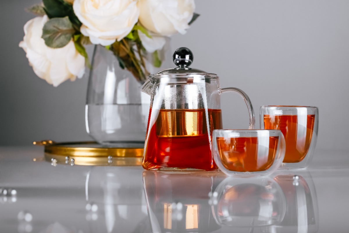Une théière avec des tasses de thé sur la table
